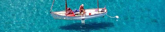 Foto: uomo in barca a vela in mare trasparente